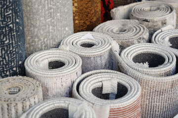 Obraz premium Various rolled rugs displayed in a market for sale