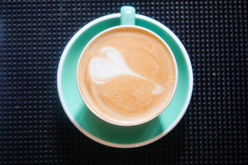 Delicious latte art served in a vibrant green cup
