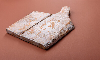 Empty wooden cutting board on a monochrome brown background