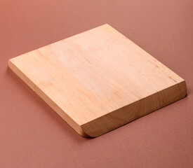 Empty wooden cutting board on a monochrome brown background