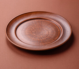Empty ceramic plate on a monochrome brown background