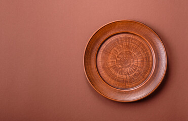 Empty ceramic plate on a monochrome brown background