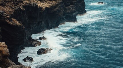 Obraz premium Dramatic Seascape: Crashing Waves Against Rugged Cliffs on a Sunny Day