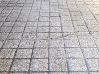 A close up of a sidewalk with a lot of small squares on it