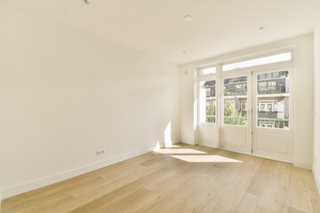 A clean and bright modern interior showcasing wooden flooring and large windows allowing natural light to fill the space. Ideal for contemporary living.