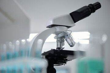 Close-up image of modern microscope with knobs and lenses reflecting laboratory's sterile...