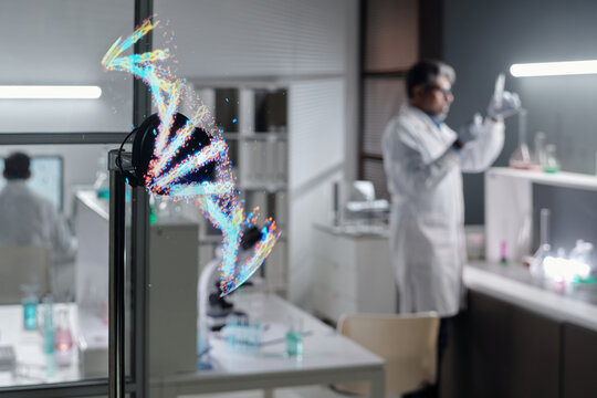 Scientist wearing white lab coat examining samples in laboratory adjusting equipment. Digital DNA strand visualization on screen emphasizing scientific advances