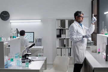 Obraz premium Researchers working in modern science lab, using microscopes and test tubes, analyzing samples and chemicals, surrounded by laboratory equipment and technology