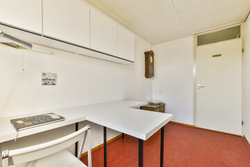 A clean and minimalist workspace featuring a white desk, simple chair, and plain walls. Ideal for promoting organization and focus in a professional setting.