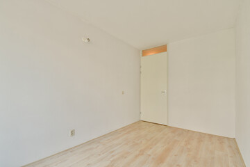 A spacious, minimalist interior featuring bare walls and wooden flooring, creating a serene and...