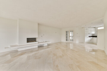A bright and spacious living room features a sleek design with white walls, smooth flooring, and a modern fireplace, creating a tranquil atmosphere for relaxation.