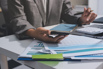 Working from home, Closeup business woman using laptop computer and analyzing financial report.