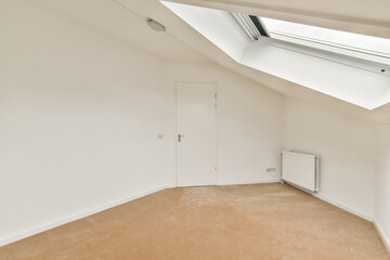 A spacious interior featuring soft light pouring through a skylight, showcasing a clean, uncluttered design with a neutral color palette.