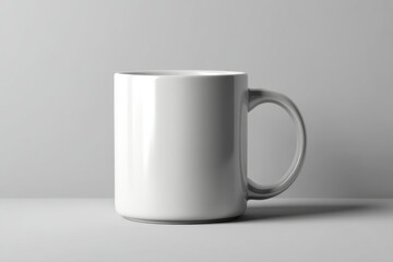 Obraz premium Plain white ceramic mug displayed on a neutral background, suitable for branding or showcasing designs