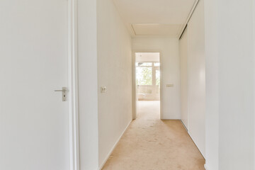 A clean, bright corridor featuring neutral tones and natural light that enhances the spacious feel of the interior. The design emphasizes simplicity and elegance.
