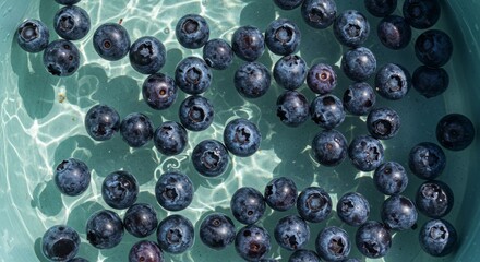 Fresh blueberries floating in clear water for a refreshing summer treat