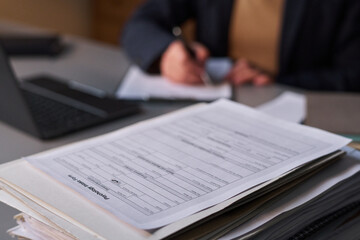 Obraz premium Focus on stack of psychological paper documents standing on workplace of modern school psychologist taking notes on background
