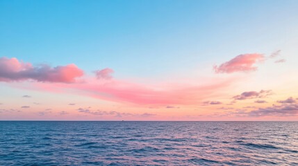 Fototapeta premium Serene ocean view at sunset with soft pink clouds and calm waves reflecting sky colors