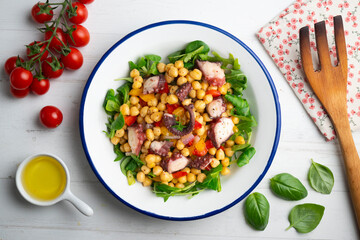 Salpicon de pulpo. Octopus salad with chickpeas, arugula and vegetables. Top view table.