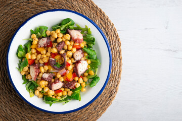 Salpicon de pulpo. Octopus salad with chickpeas, arugula and vegetables. Top view table.