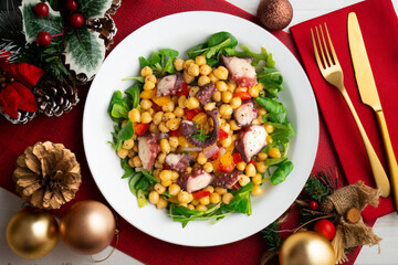 Salpicon de pulpo. Octopus salad with chickpeas, arugula and vegetables. Top view table with christmas decorations.