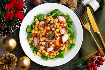 Salpicon de pulpo. Octopus salad with chickpeas, arugula and vegetables. Top view table with christmas decorations.