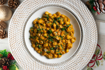 Chickpea curry with eggplant and vegetables. Top view table with christmas decorations.