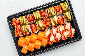 Colorful assortment of sushi rolls displayed on a black tray