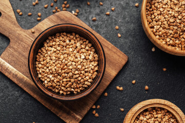 Buckwheat grains in wooden bowls prepared for cooking in a kitchen setting