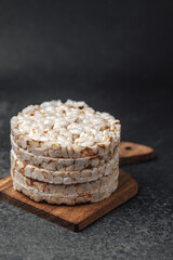 Crisp rice cakes stacked on a wooden board in a minimalistic setup