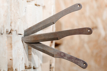 three metal knives in wooden block stand as target, throwing knives, sports competition, selective focus