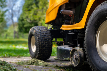 Lawn mover. Moving grass with the help of a small garden tractor.