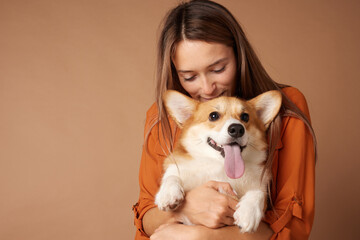 Joyful Corgi cuddled by a loving woman, showing happiness, loyalty, warmth, and companionship.