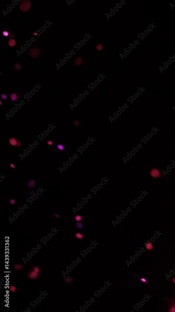 Poster a cosmic scene with scattered particles of bright red and purple on a deep black background. the sof