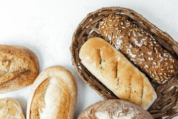 Freshly baked bread assortment in a rustic basket on a neutral background