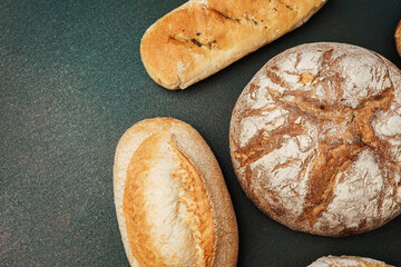 Freshly baked artisan breads displayed on dark table