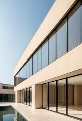 Fototapeta premium A spacious, shimmering blue pool stretches out in front of a modern building, surrounded by lush greenery and comfortable lounge chairs for relaxation.