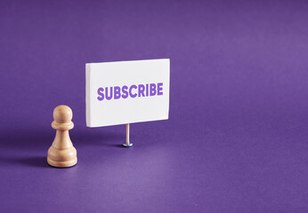Chess pawn standing next to the banner with the word subscribe