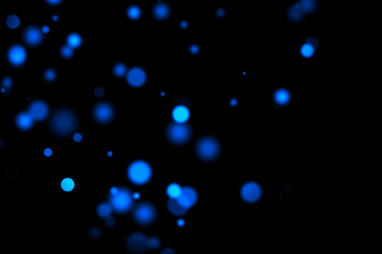 Dark background with floating soft blue glowing bokeh circles overlay. party effect backdrop festive or digital light overlay