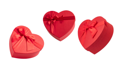 Set of three red heart shaped gift boxes with ribbons on transparent background