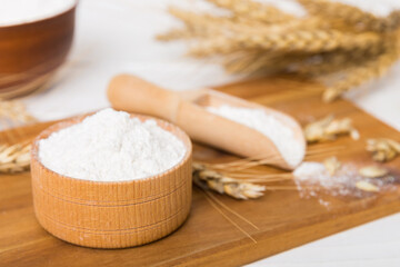 Flat lay of Wheat flour in wooden bowl with wheat spikelets on colored background. world wheat...