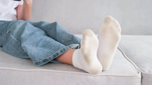 The child has dirty socks. The girl uses a mobile phone