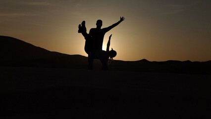 Paar beim Sonnenuntergang in der Wüste, romantische Stimmung. Künstliche Intelligenz KI