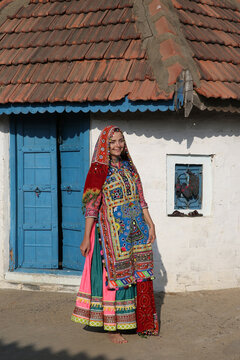 Beautiful young woman, tourist girl in traditional national Indian costume, Meghwal folk dress. Village, India. Indian local people. Tribal native woman, Meghwal tribe in Gujarat. Bride, house, home