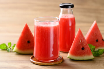 Fresh watermelon juice in glass and bottle on wooden background, Summer drink