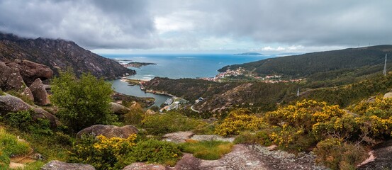 Fototapeta premium Panoramic coastal landscape with village and greenery.