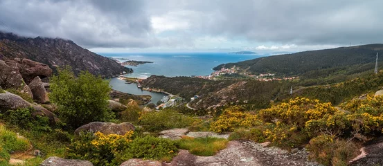 Papier peint photo  Panoramic coastal landscape with village and greenery.  © Wirestock