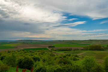 Rolling hills and expansive skies capture the serene beauty of a rural landscape in springtime