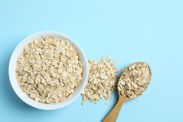 Composition with oatmeal flakes on blue background. Cooking breakfast