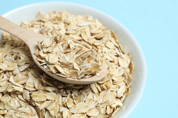 Composition with oatmeal flakes on blue background. Cooking breakfast
